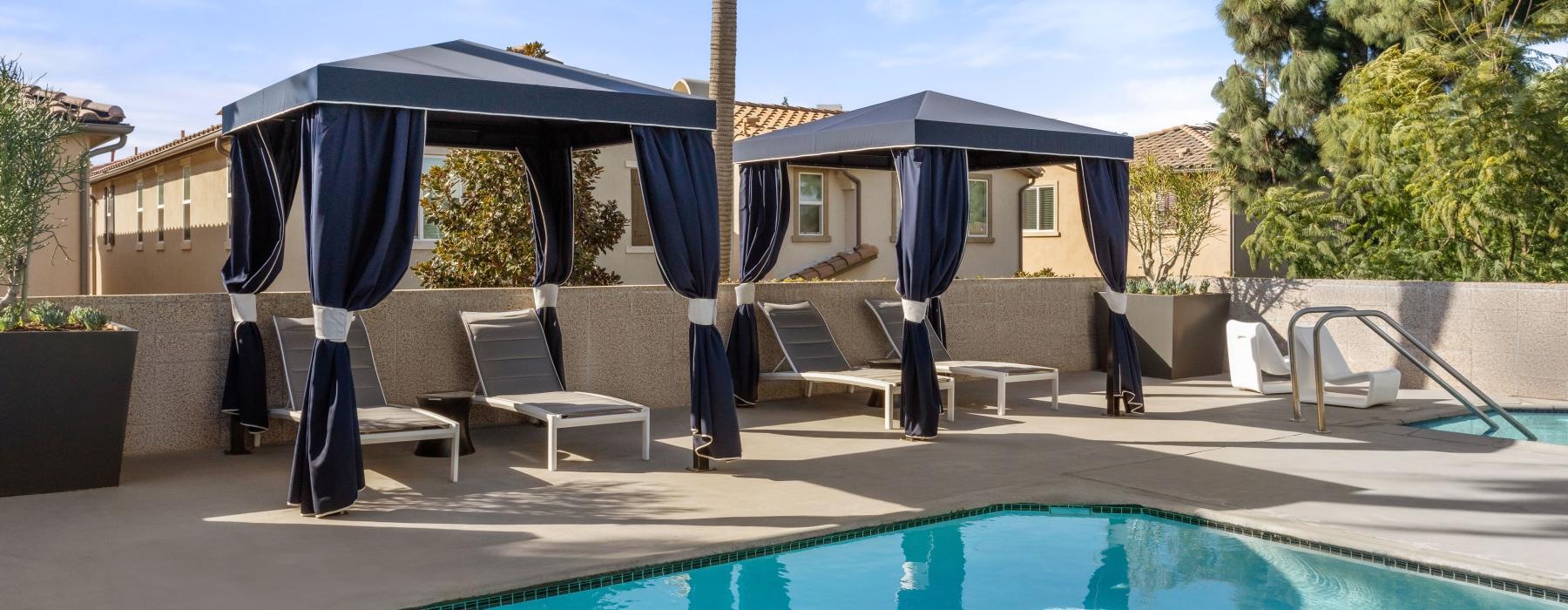 a pool with a couple of chairs and a couple of umbrellas by it