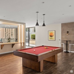 Looking for a fun and friendly atmosphere to socialize? Our apartments offer two amazing entertainment pavilions with free Wi-Fi, billiard tables, TV lounges, and a comfortable dining area. Join the fun today. game room with a pool table and a table and chairs