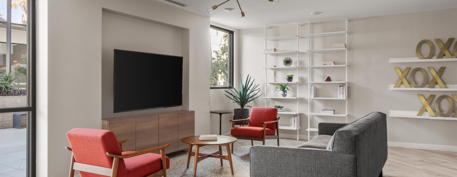 a living room with a tv and chairs