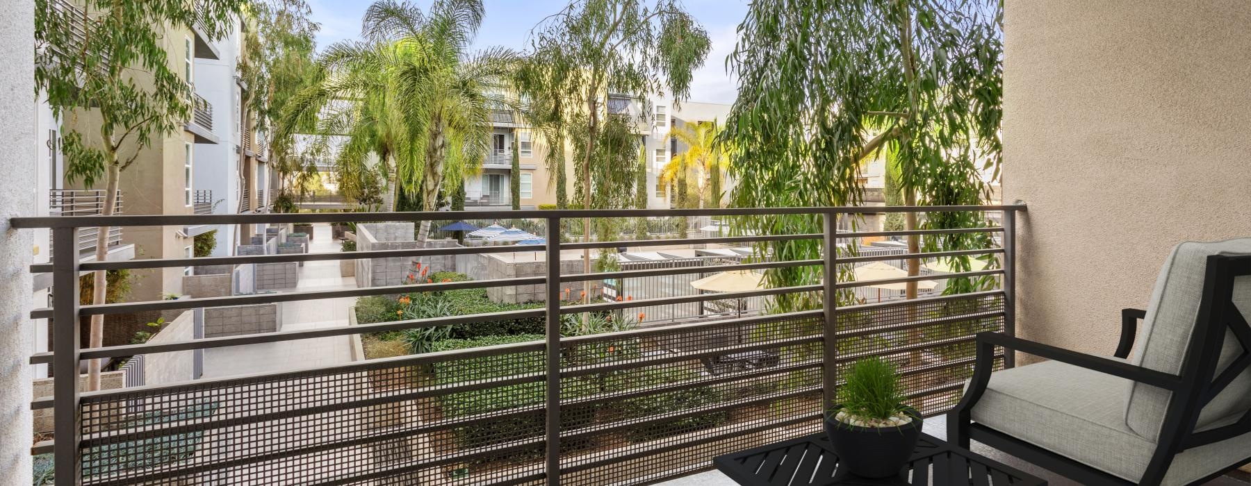 a patio with a table and chairs and trees and a building