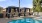 a pool with a couple of chairs and a couple of umbrellas by it